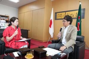 ラジオ出演中の徳永さんと安川町長