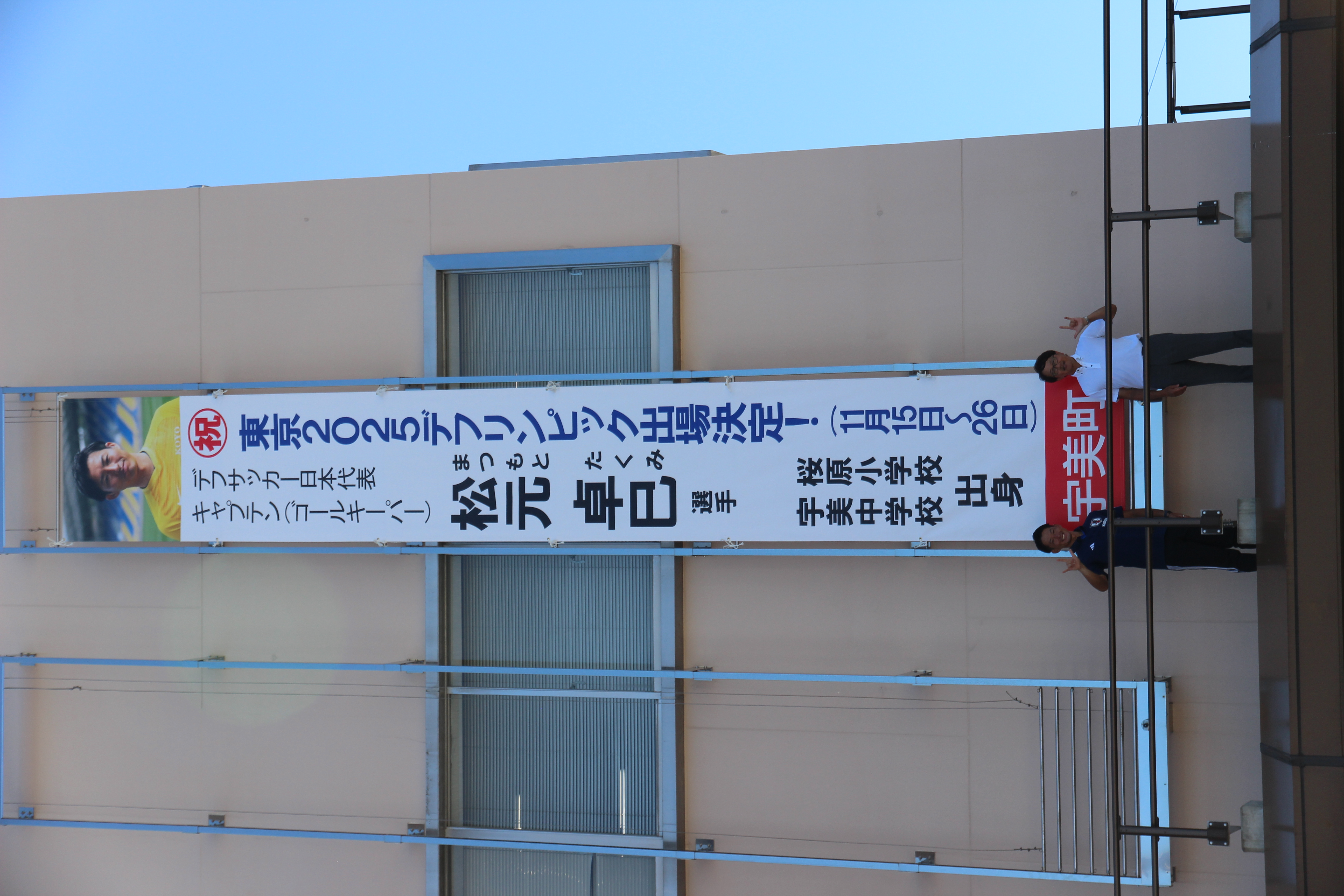 懸垂幕前で記念撮影