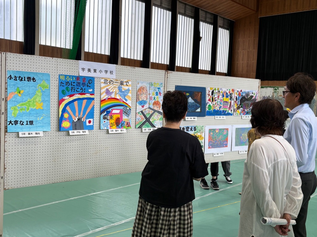 宇美東小学校の児童による選挙ポスターを、町民の方々とともに鑑賞する安川町長