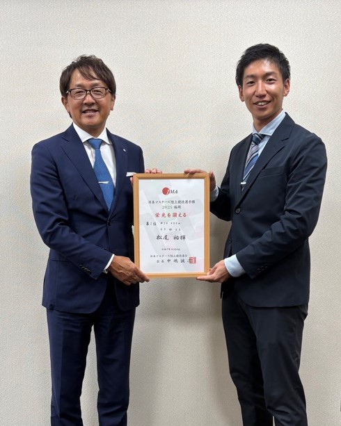 松尾さんと町長が笑顔で賞状を掲げている写真