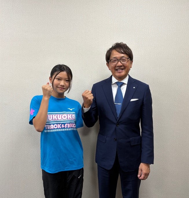 記念撮影で町長と一緒にガッツポーズをする岸本さん