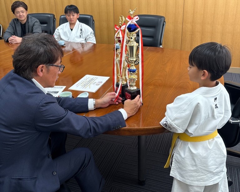颯士くんのトロフィーを見る町長