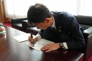 サインを書く金監督