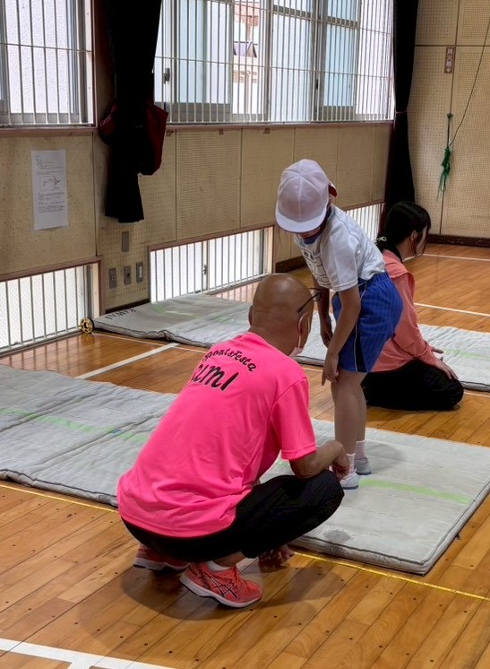 桜原小学校で立ち幅跳びの測定をする津田委員