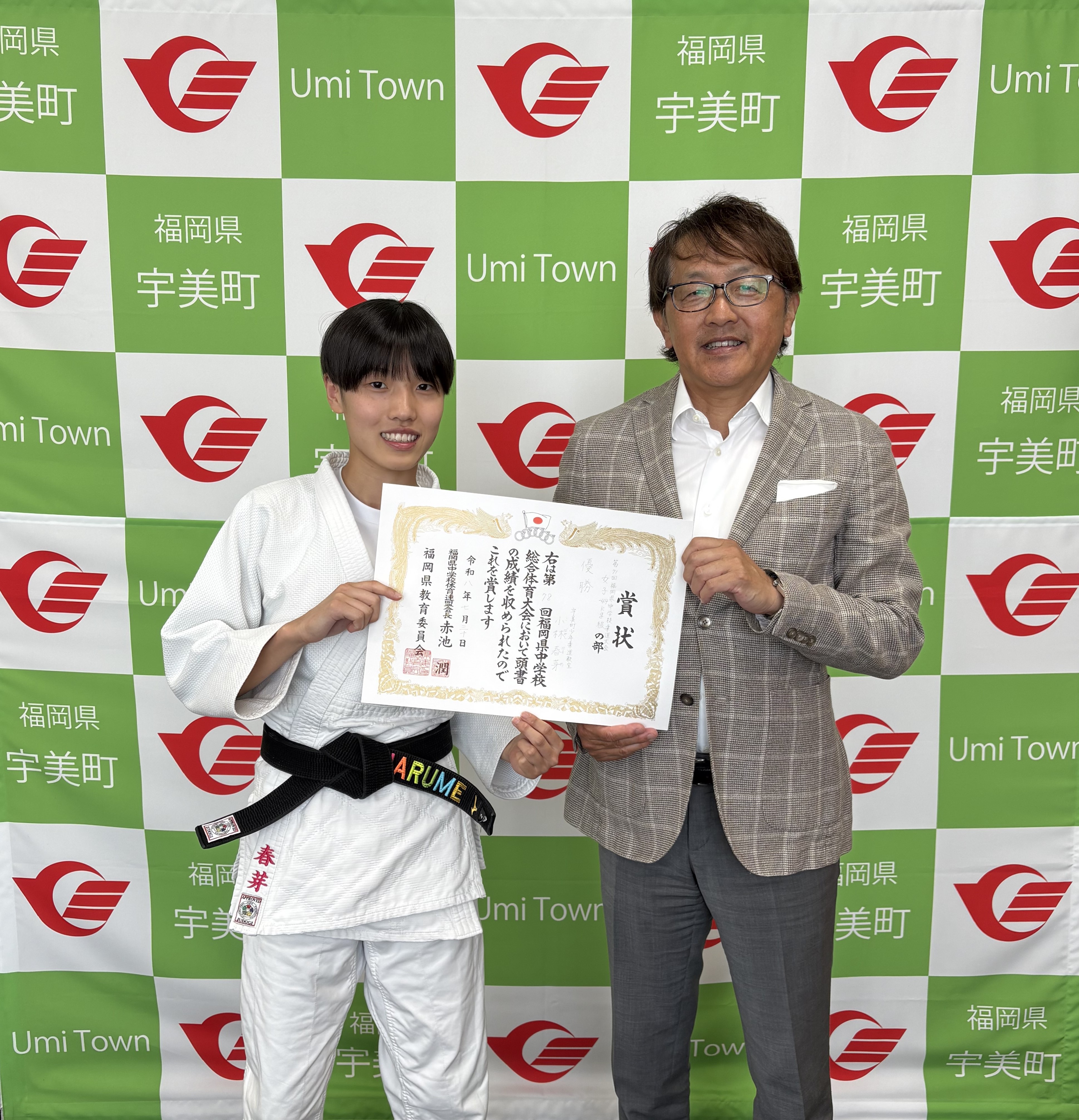 県大会優勝の賞状を持って記念撮影をする小林さんと町長